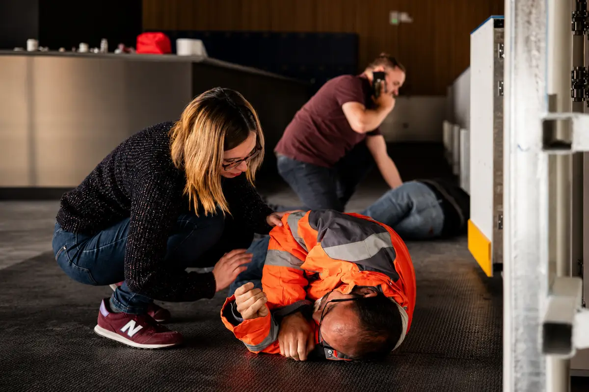 Mise en situation SST : une apprenante met en sécurité une victime au sol pendant qu’un collègue donne l’alerte